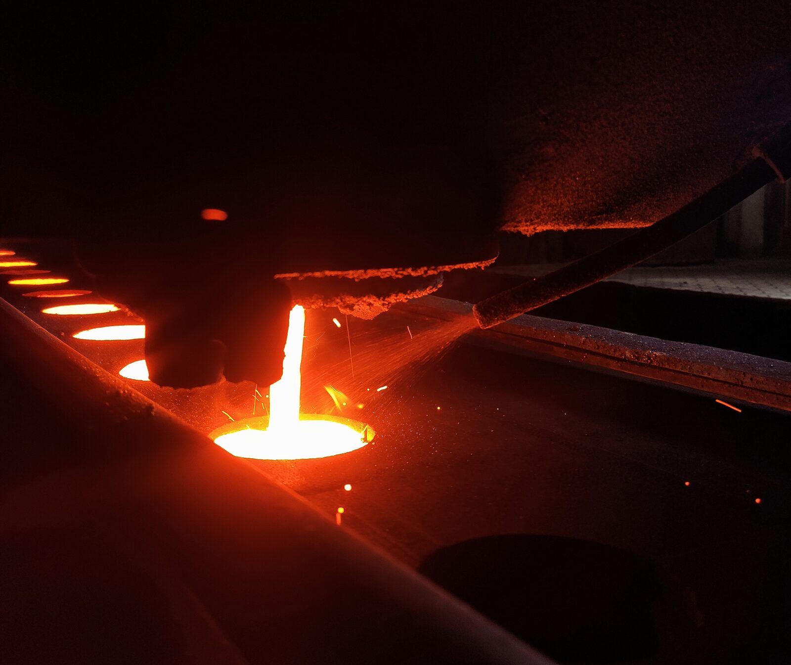 In-stream inoculation addition while molten cast iron is poured to a green sand mold in a foundry in Bangladesh - via Wikimedia Commons (used under CC BY-SA 4.0)